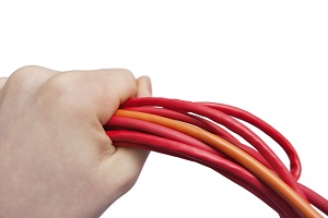 Cropped image of technician holding computer hardware cables over white background