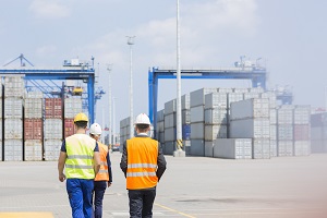 Rear view of workers walking in shipping yard